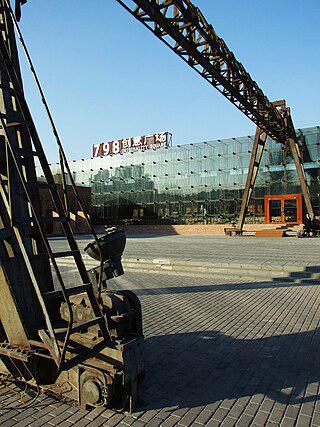 На территории пекинской зоны искусств из трубопроводов вырывается пар и разгружают уголь промышленными кранами. Фото 3 